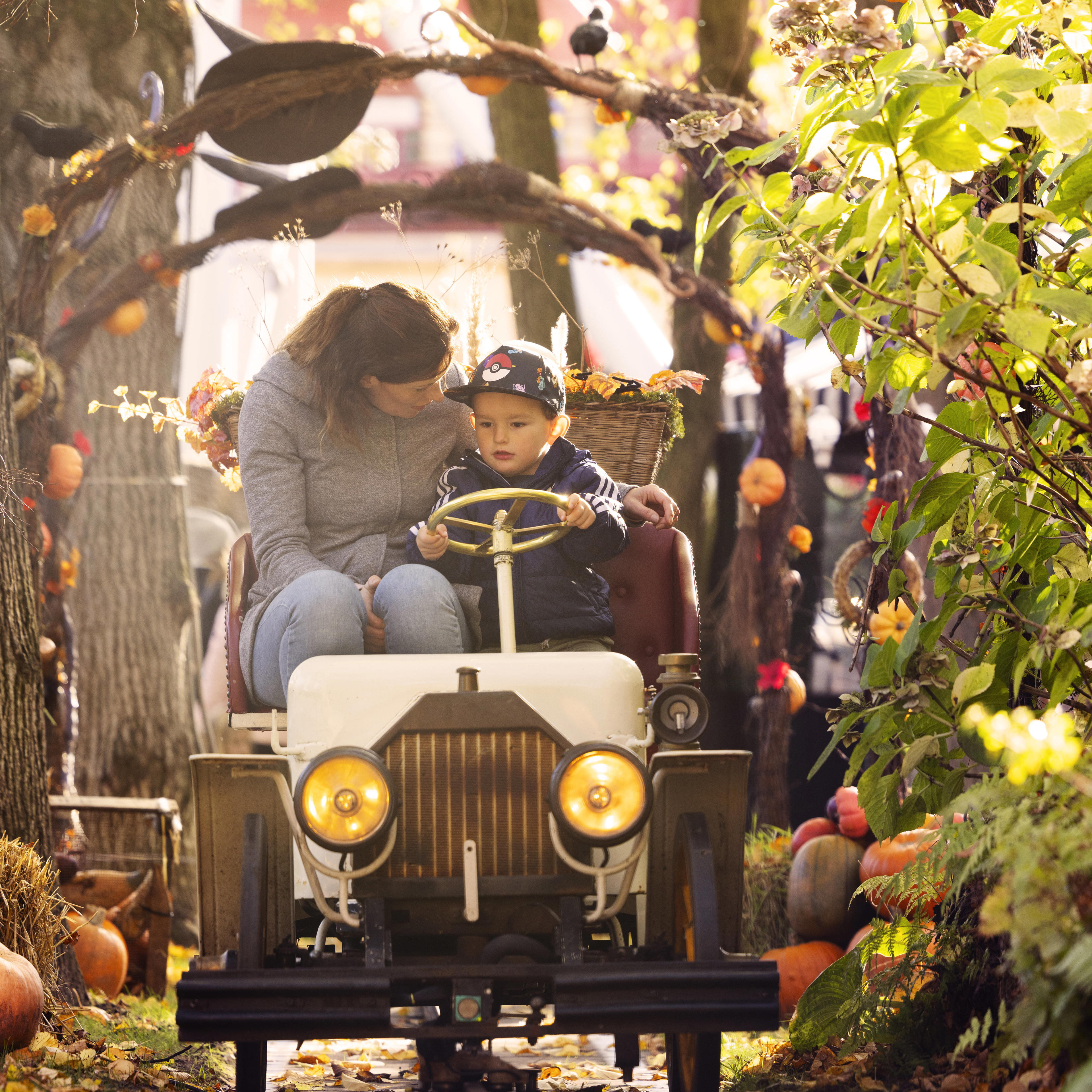 Mother and son in The Vintage Cars surrounded by autumn decorations with pumpkins and witch hats